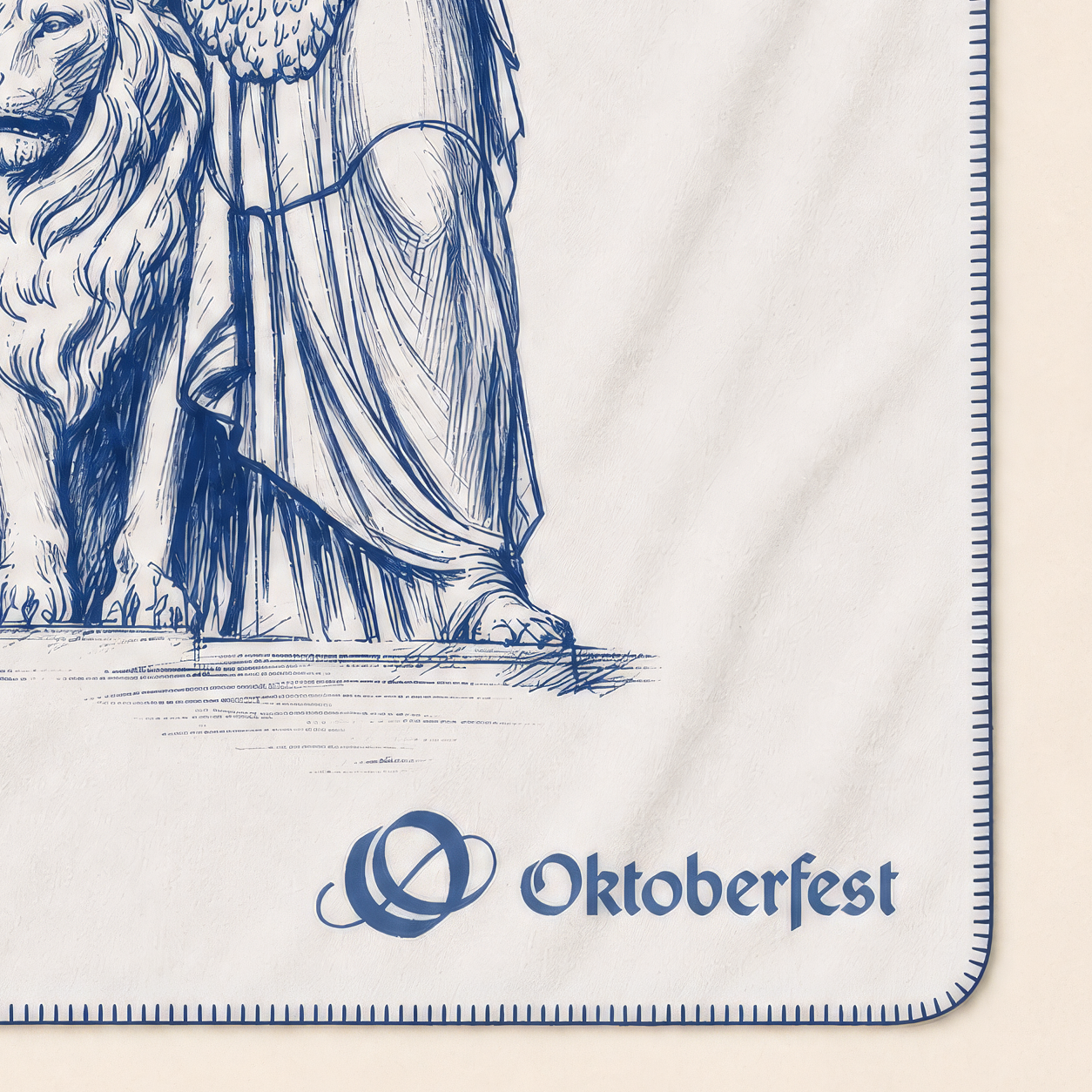 Offiziell lizenzierte Oktoberfest™ Decke von KOLTER® in Natur mit blau eingewebtem Wiesn-Motiv: Bavaria und Löwe. Detailansicht der Deckenecke