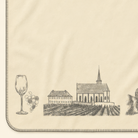 Kolter Decke mit Wein, Gläsern, Kirche und Fachwerkhäusern.